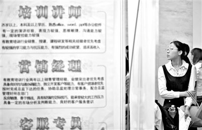 5月18日，农展馆人才招聘会上，一求职者在看招聘信息。新京报记者 薛珺 摄